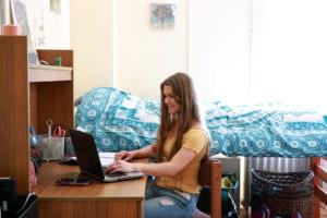 A student working on a computer in a dorm room